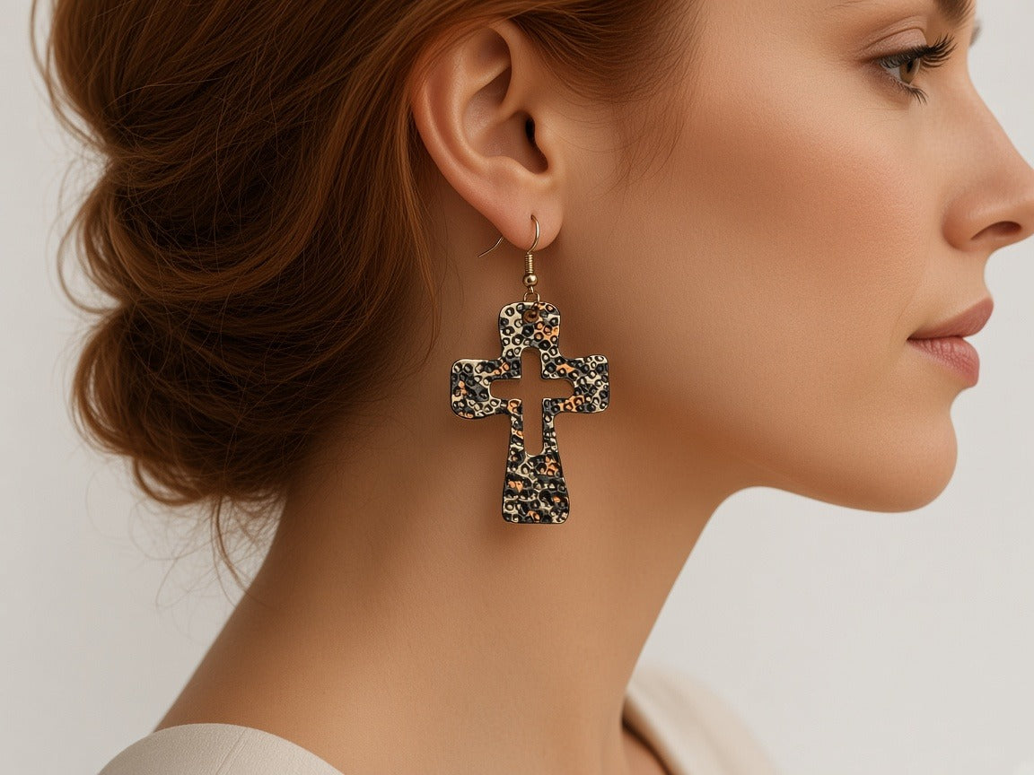 Earrings - leopard print cross worn by a model